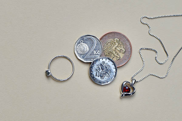 kovové mince a stříbrné šperky