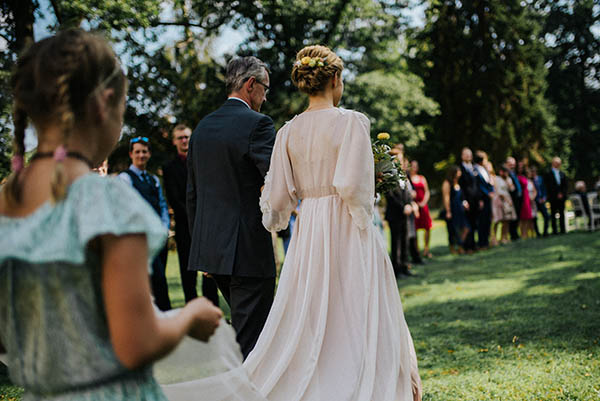 Nevěsta v bílých svatebních šatech jdoucí k oltáři