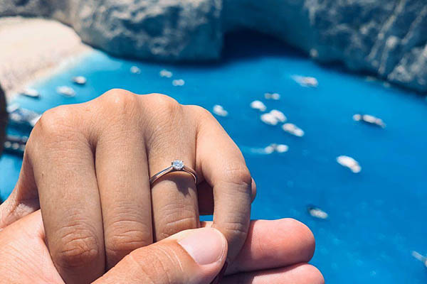 Foto prstenu na prstu snoubenky u moře